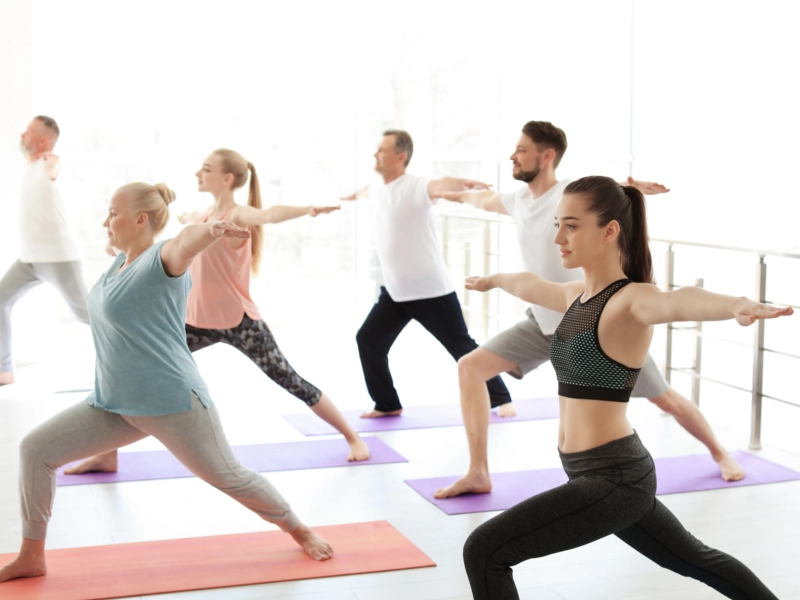Teilnehmer machen gemeinsam Rehasport Übungen auf Matten zur Stärkung, Koordination und gesundheitsorientierten Bewegung